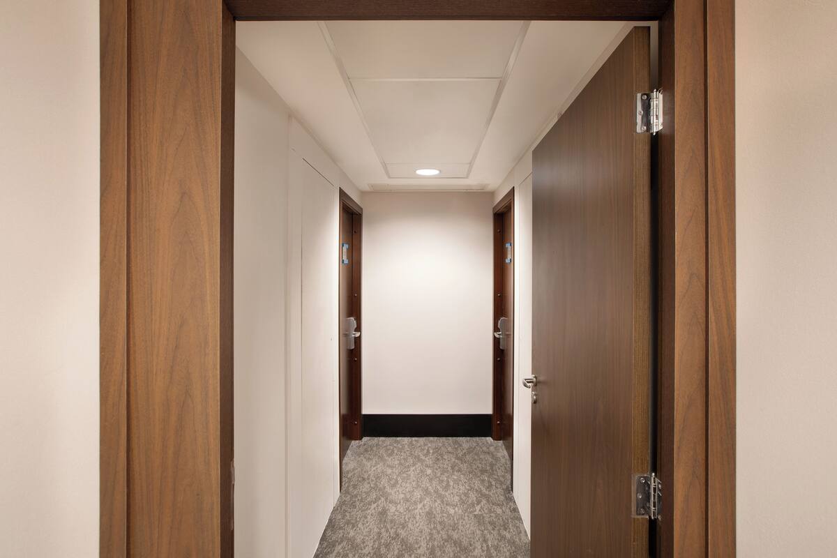 Un pasillo con puertas de madera y suelo alfombrado.