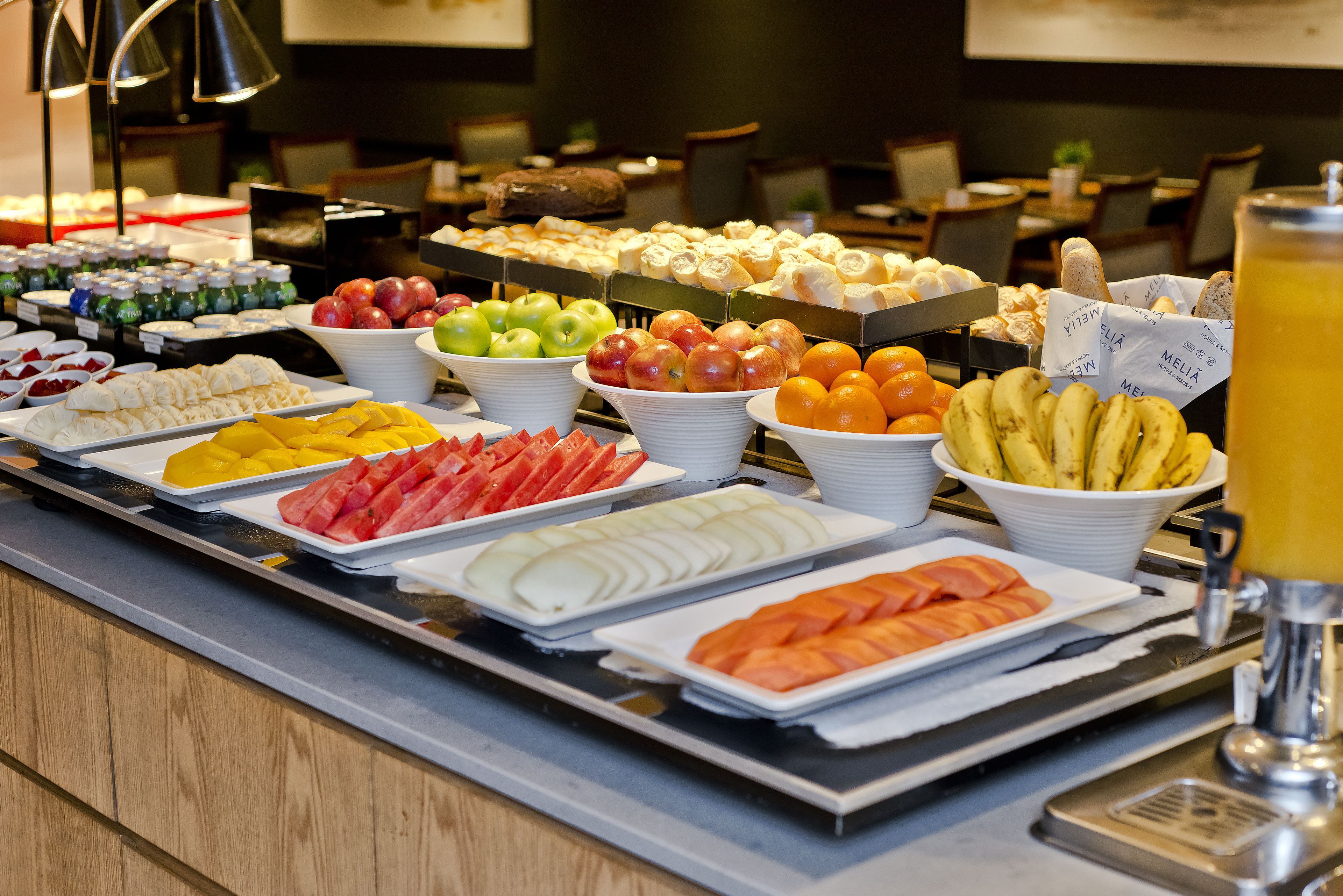 A buffet with various fruits and pastries.