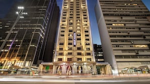 Un grand hôtel, reconnaissable à son enseigne imposante, entouré d’autres immeubles de grande hauteur.