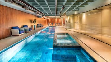 Una piscina techada, sillones reclinables de piscina