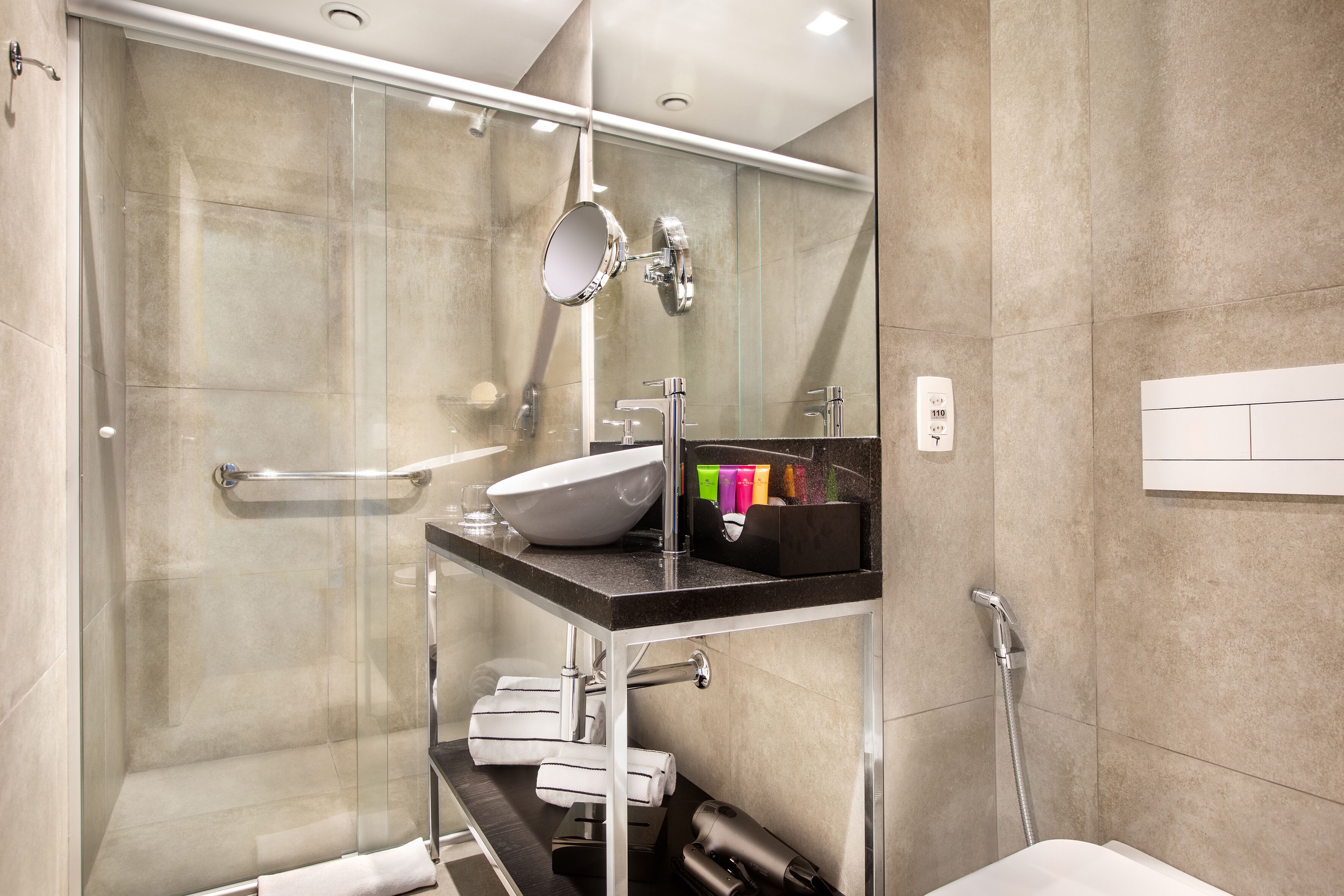 Une salle de bain moderne avec une douche à parois de verre, un meuble-lavabo et un miroir.