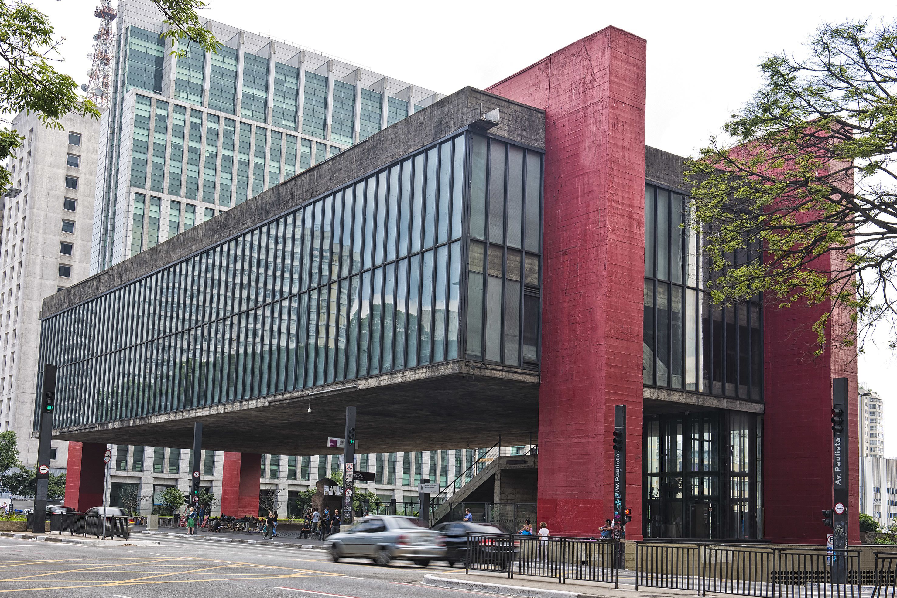 Un bâtiment moderne doté de grandes fenêtres en verre et d’une façade en briques rouges.