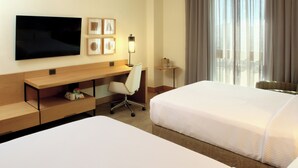 A hotel room with two beds, a desk, a chair, a TV mounted on the wall, and a window with curtains. - Crowne Plaza Torreon by IHG (Torreón)