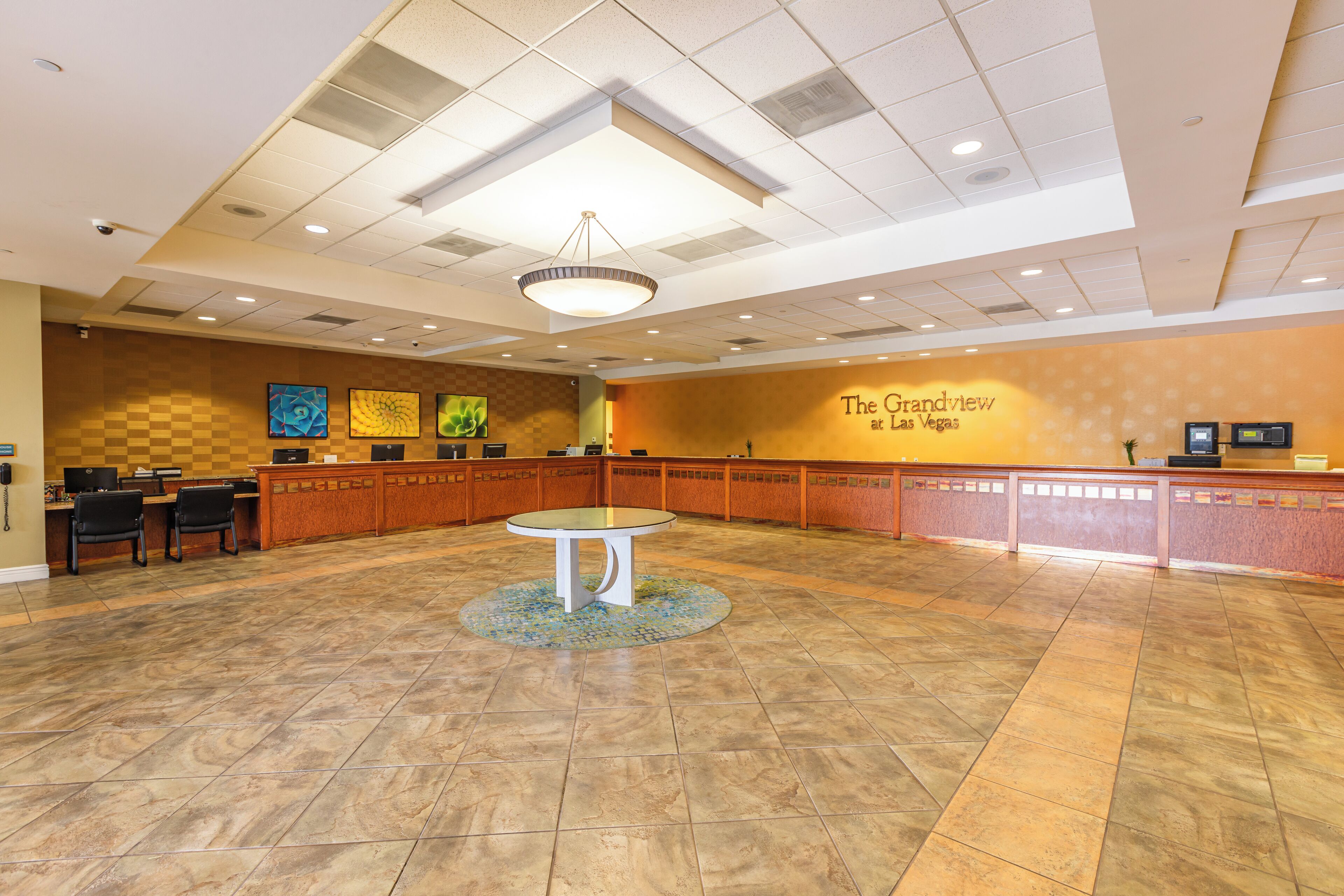 En rummelig lobby med en receptionsdisk, et rundt bord i midten, og en væg med teksten "The Grandview at Las Vegas".