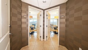 A hotel corridor with mirrored walls, a conference room with chairs and tables, and a city view. - Grandview at Las Vegas (Las Vegas)