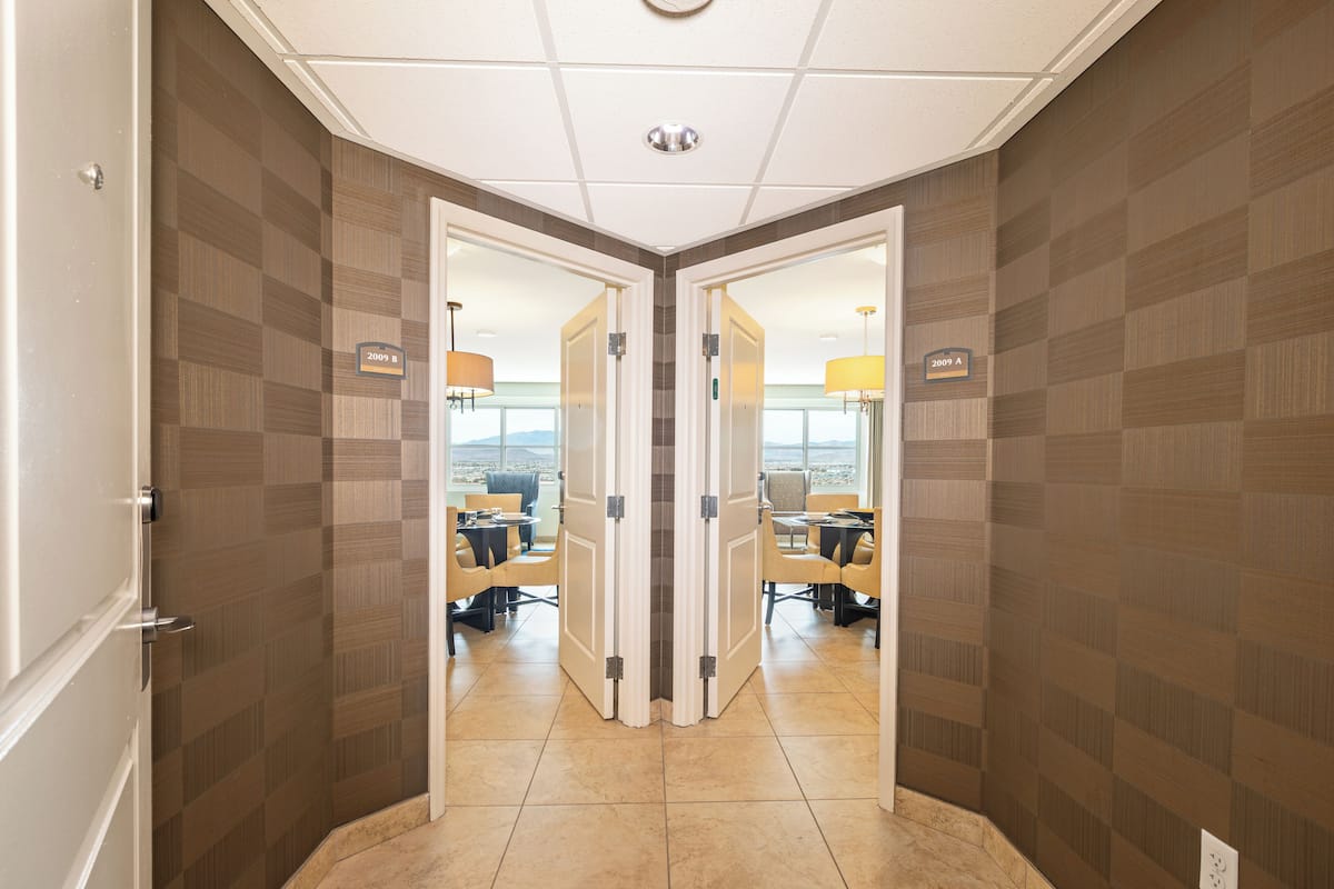 A hotel corridor with mirrored walls, a conference room with chairs and tables, and a city view.