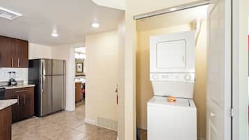 A compact kitchen with a refrigerator, a washer, and a dryer.