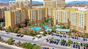 A high-rise hotel with multiple floors, a swimming pool, and a parking lot. - Grandview at Las Vegas (Las Vegas)
