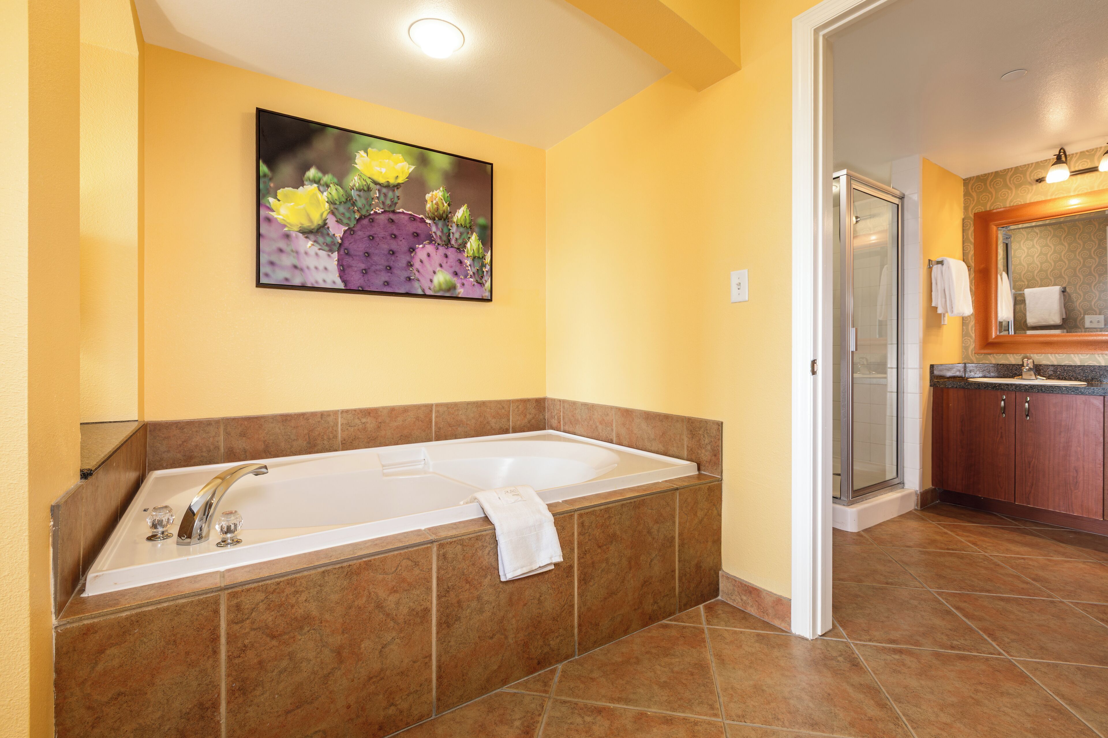 A bathroom with a large bathtub, a shower, and a sink.