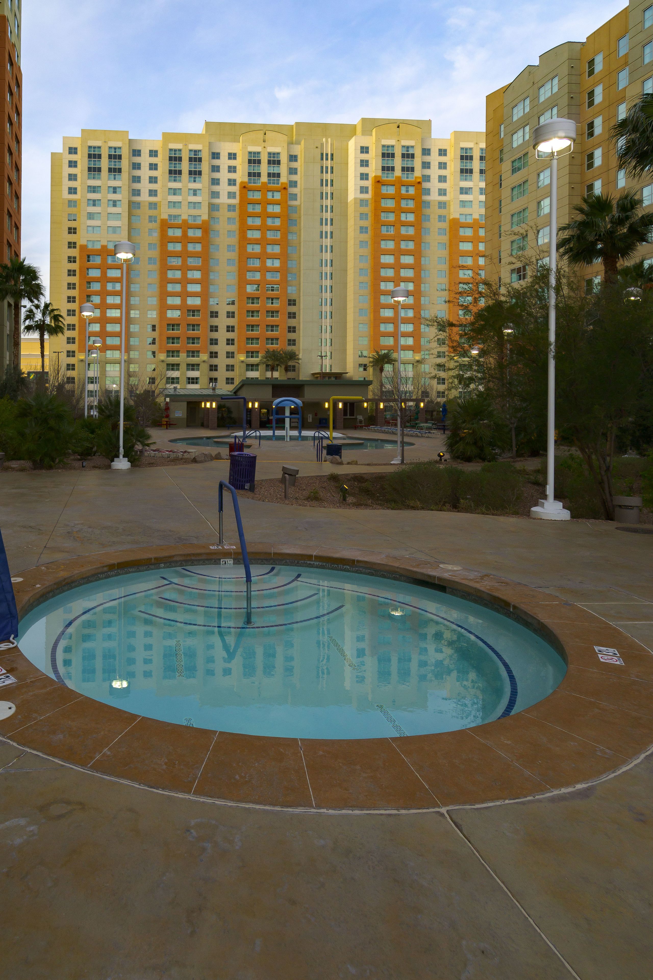Un espace piscine d’hôtel offrant une vue dégagée sur la façade du bâtiment.