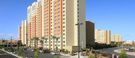 A multi-story hotel with a parking lot in front.