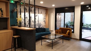 Una moderna zona de recepción con un sofá, una mesa de centro y una pared decorativa.