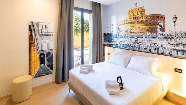 Una habitación de hotel con una cama grande, una mesita redonda y un ventanal con cortinas.