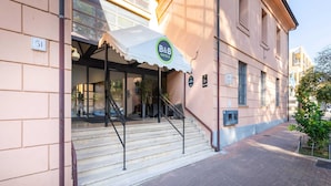 Entrada de hotel con un espacio exterior cubierto, escalones que conducen a la entrada y un cartel que indica que es un B&B.