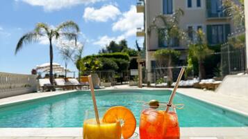 Seasonal outdoor pool, open 10:00 AM to 8:00 PM, pool umbrellas