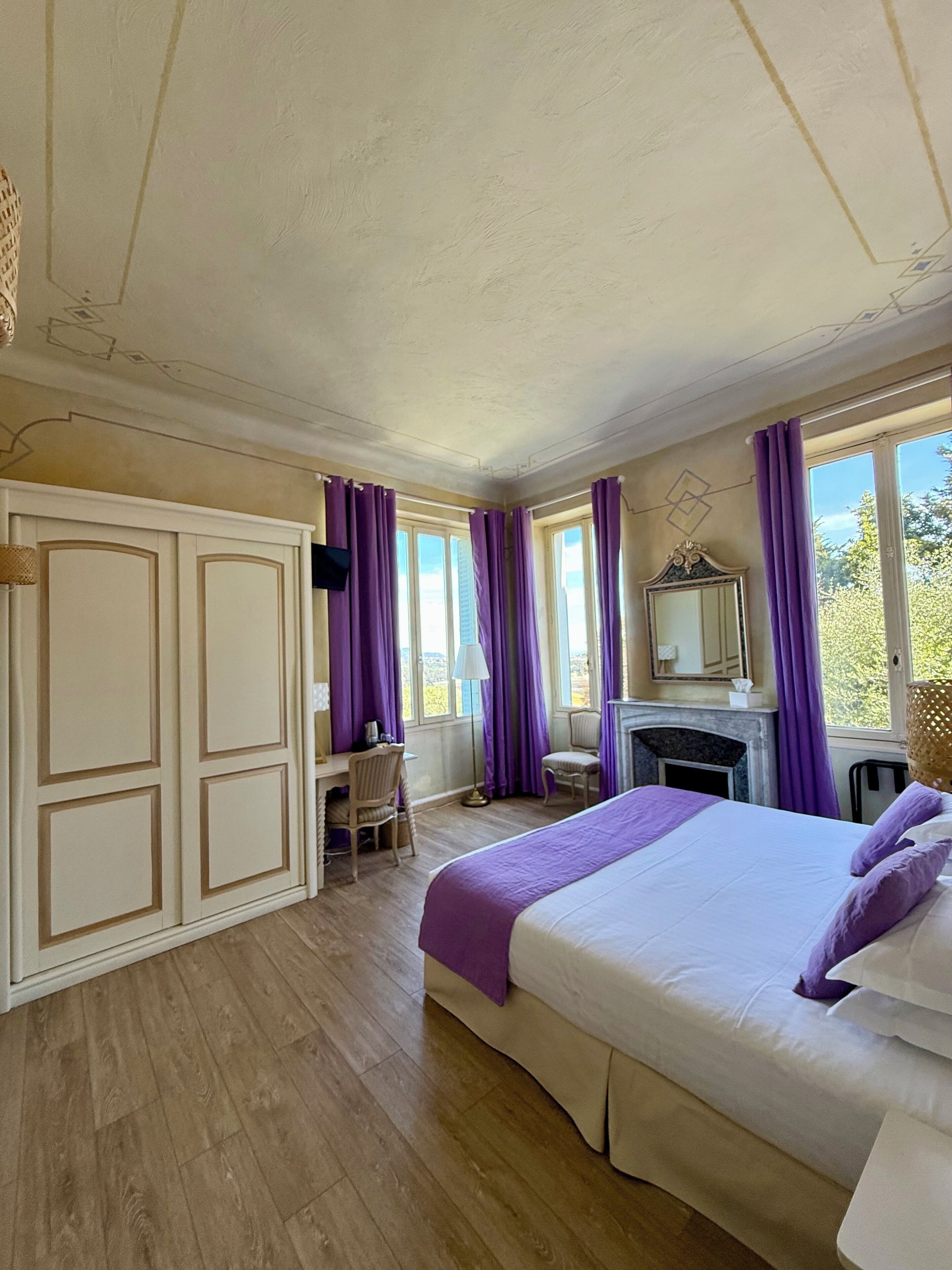 Une chambre à coucher avec un lit, un bureau, une chaise et une cheminée.