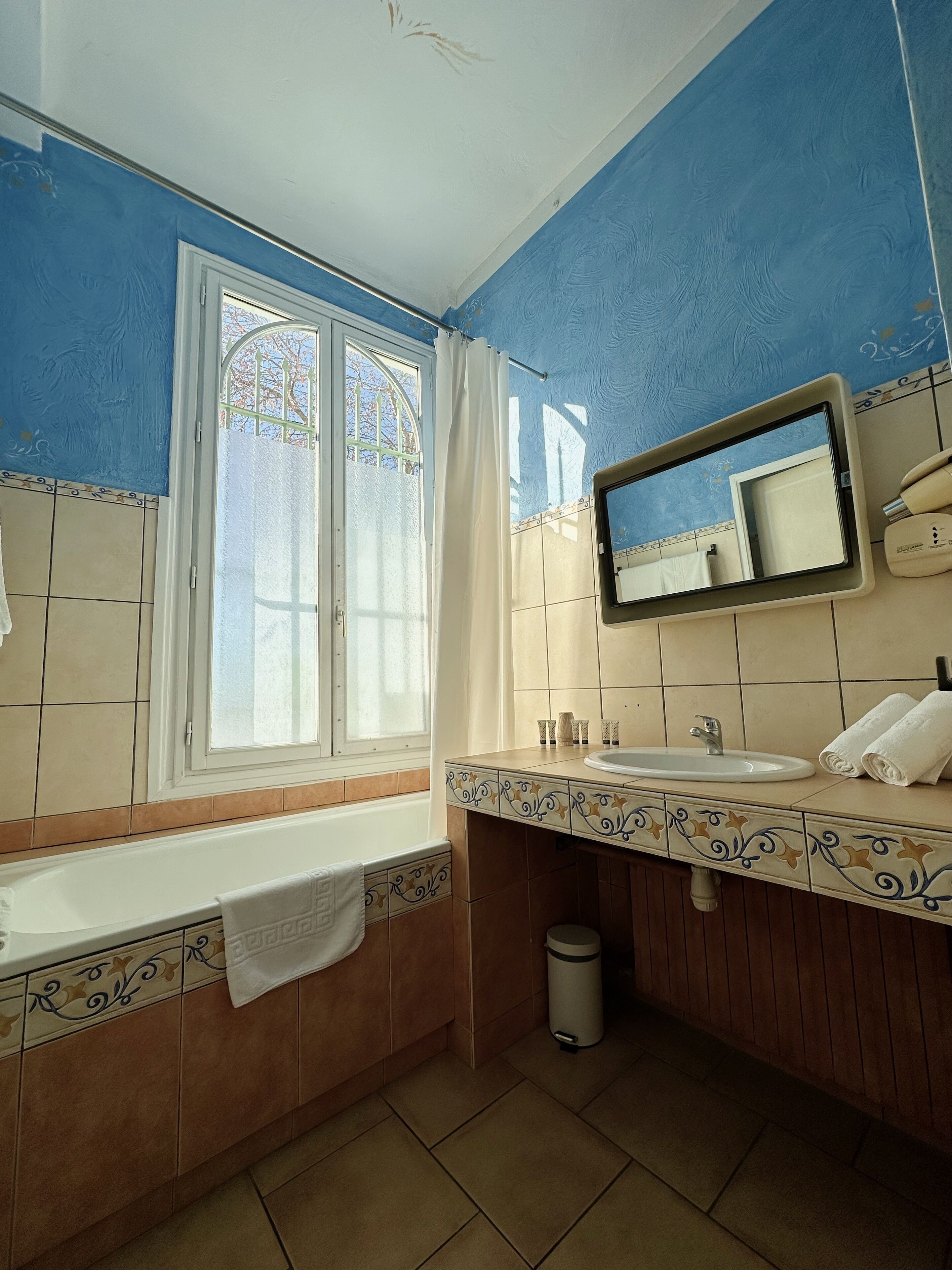 A bathroom with a bathtub, a sink, and a mirror.
