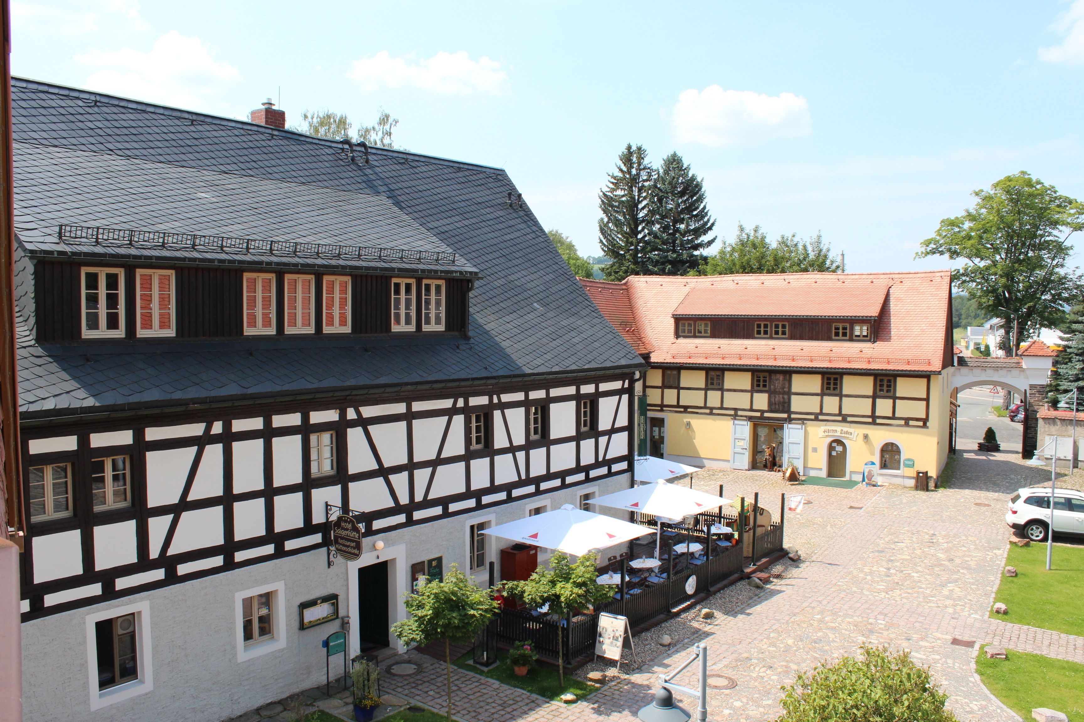 Ein traditionelles Fachwerkhäus mit Innenhof, Außenbereich und einem sichtbaren Restaurantschild.