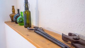 A wooden shelf with various glass bottles and a pair of old-fashioned scissors.