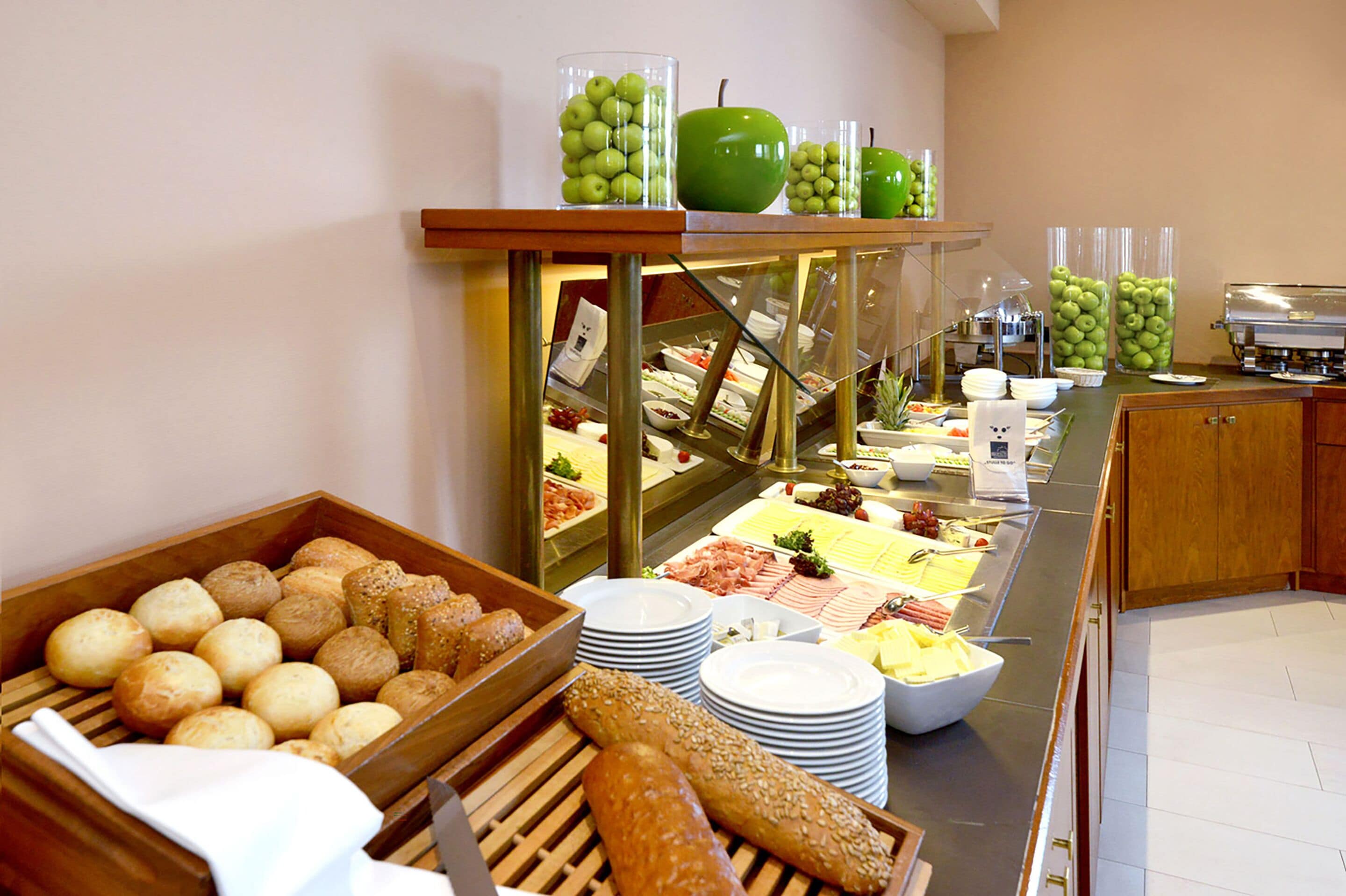 Un buffet proposant une variété d’aliments, notamment du pain, du fromage et des fruits.