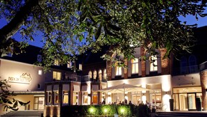 A hotel with a courtyard, outdoor seating, and a fountain. - Parkhotel Berghoelzchen (Hildesheim)