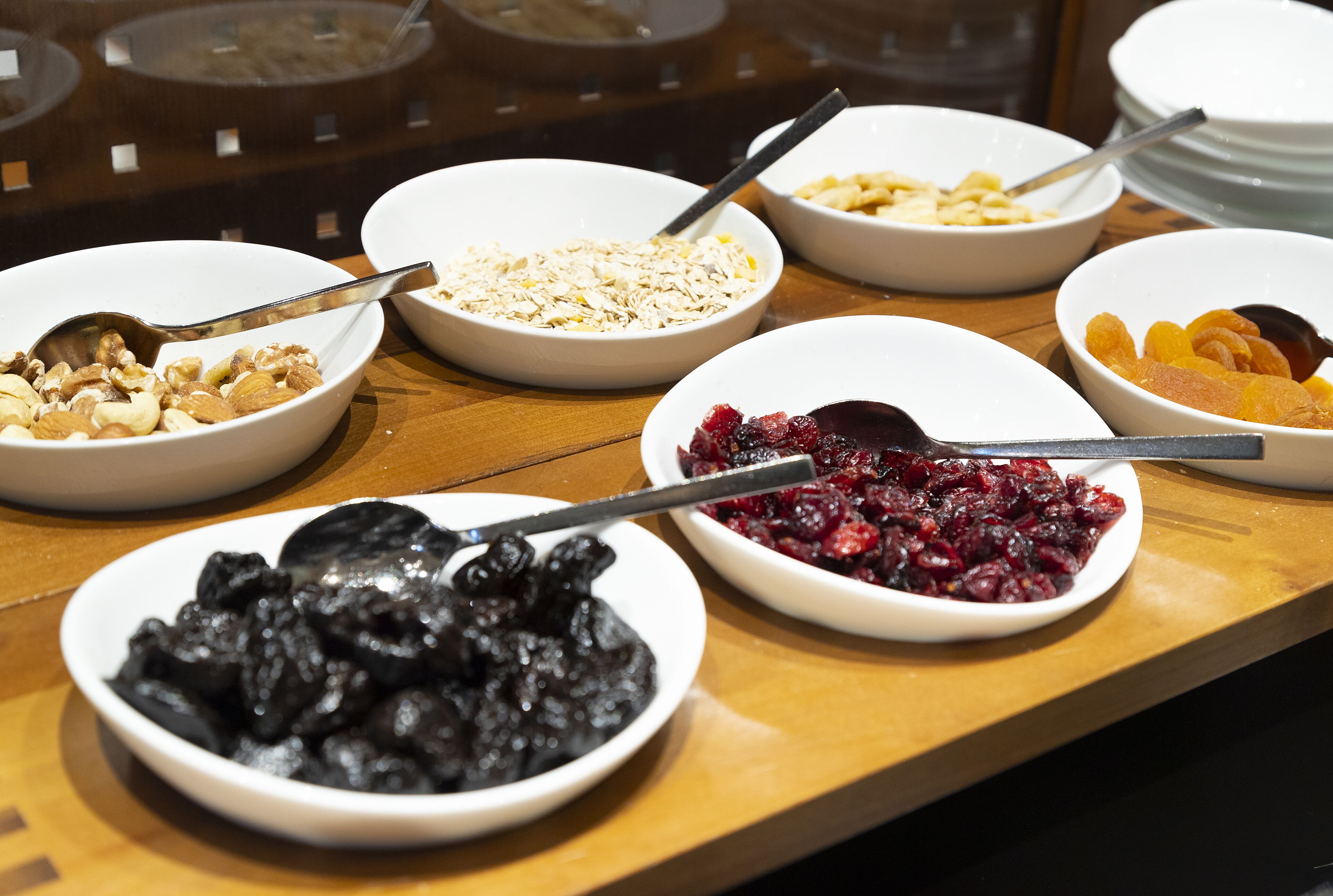 A buffet with various dishes including fruits, nuts, and cereals.