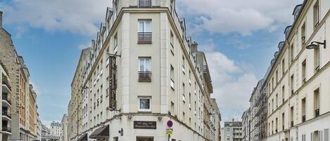 Un edificio en esquina con un letrero que dice 'Hotel Le Grand Vieux Paris'.