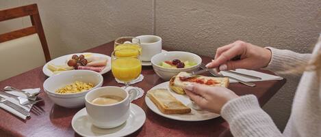 Una escena de desayuno con diversos alimentos y bebidas sobre una mesa.