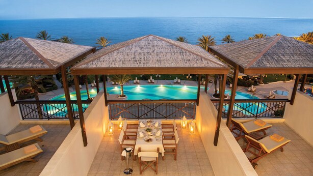 Une terrasse sur le toit avec une piscine, un espace repas et une vue sur la mer.