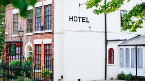 A hotel with a white facade and a red brick section.