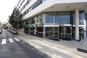 Ein moderner Hotel Eingang mit Glasfassade, einer Drehtür und einem sichtbaren Euro Hotel Schild.