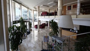 Tilava aula, jossa on korkeat katot, suuret ikkunat ja useita oleskelualueita.