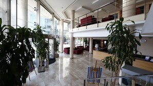 Tilava aula, jossa on korkeat katot, suuret ikkunat ja useita oleskelualueita.