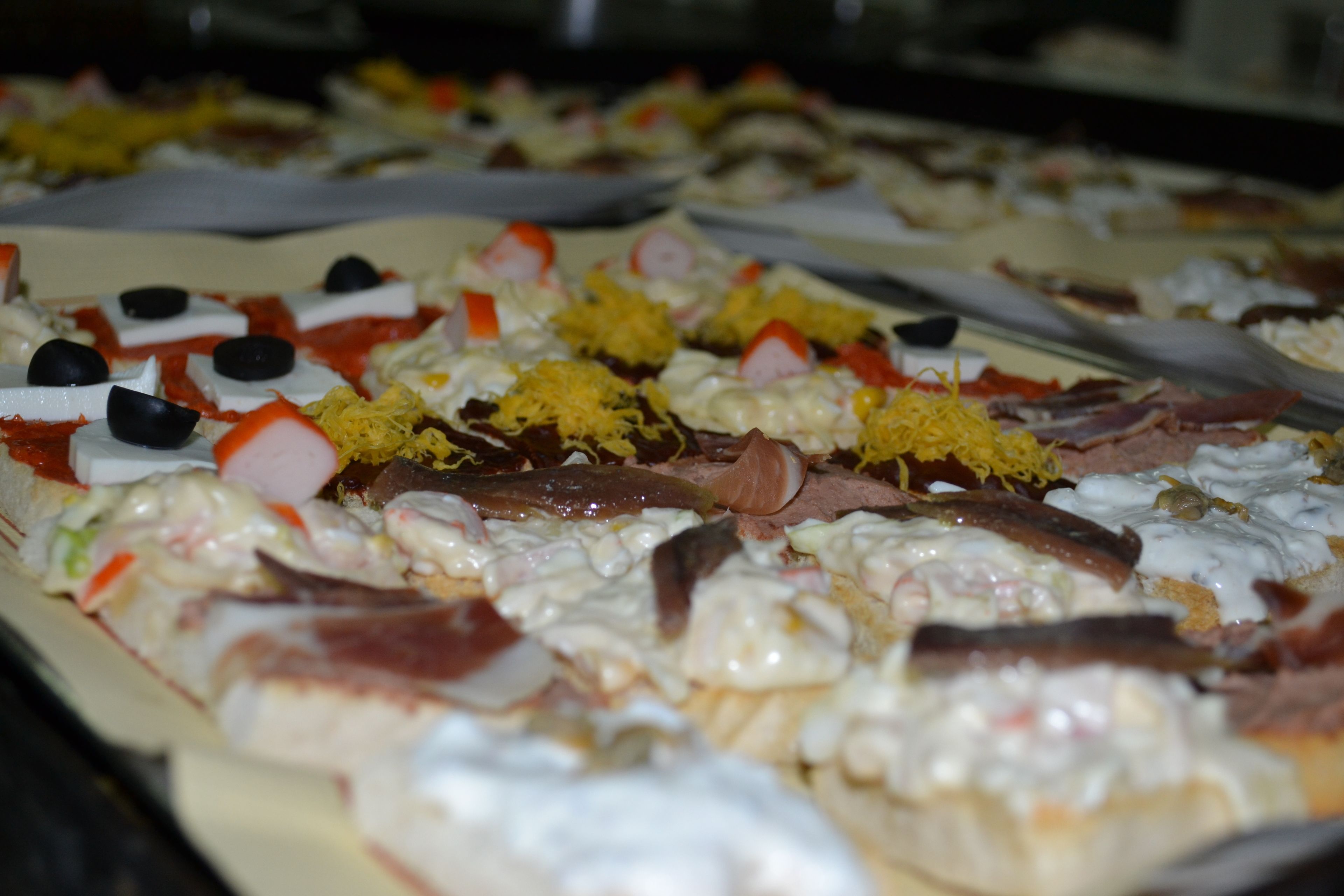 A buffet with various dishes including meats, cheeses, and garnishes.