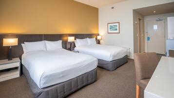 Une chambre d’hôtel avec deux lits, un bureau et une chaise.