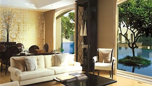 A modern living room with a sofa, armchairs, a coffee table, and a bookshelf.