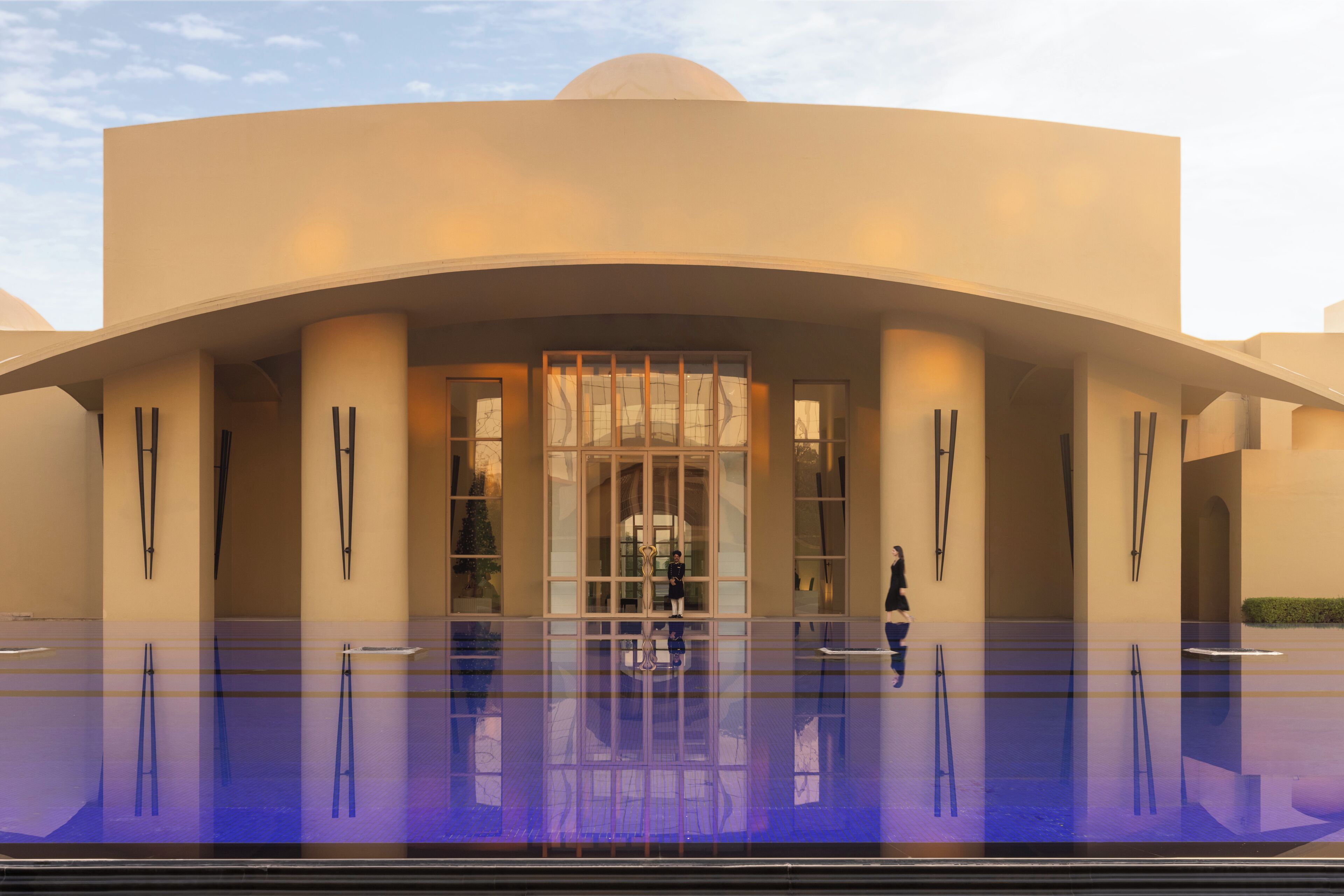 A modern building with a curved facade, large glass windows, and a central entrance.