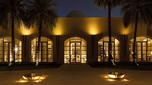 A building with arched windows and palm trees.