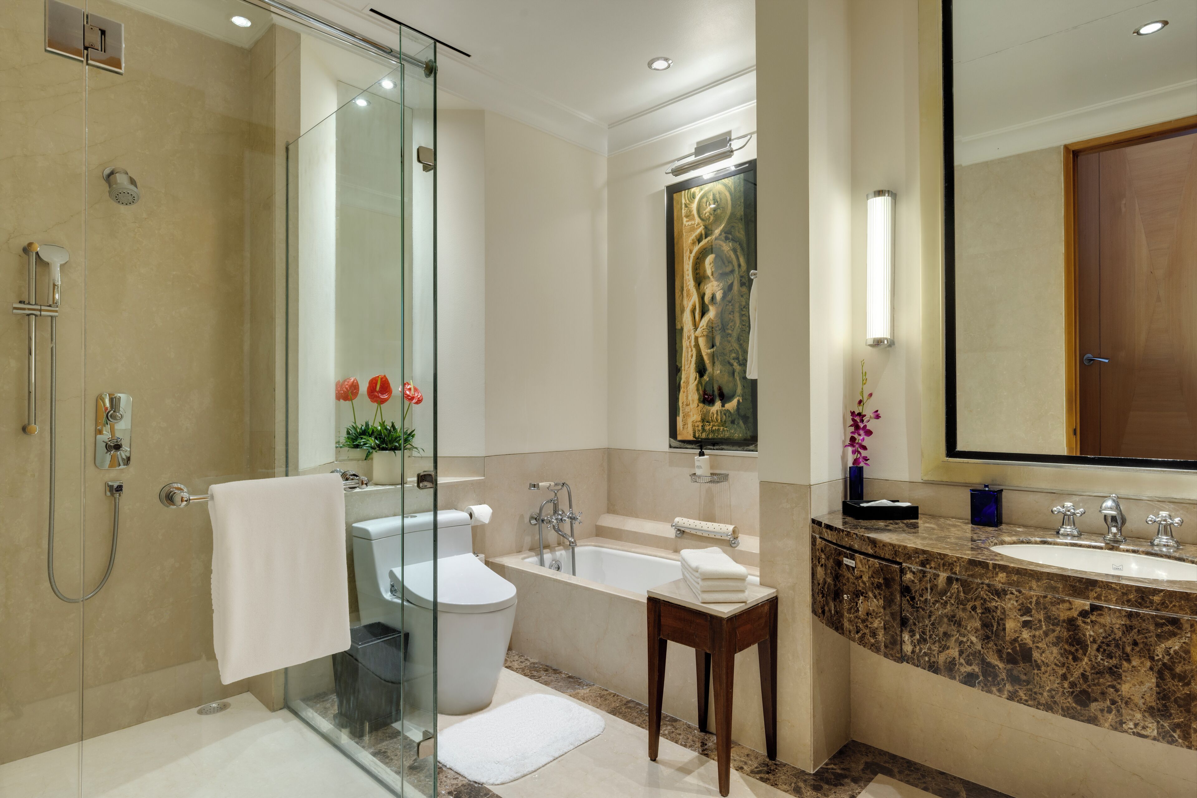 Un baño moderno con ducha envuelta en vidrio, una bañera, un inodoro y un lavamanos.