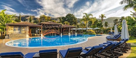 Piscine couverte, piscine extérieure, parasols de plage, chaises longues