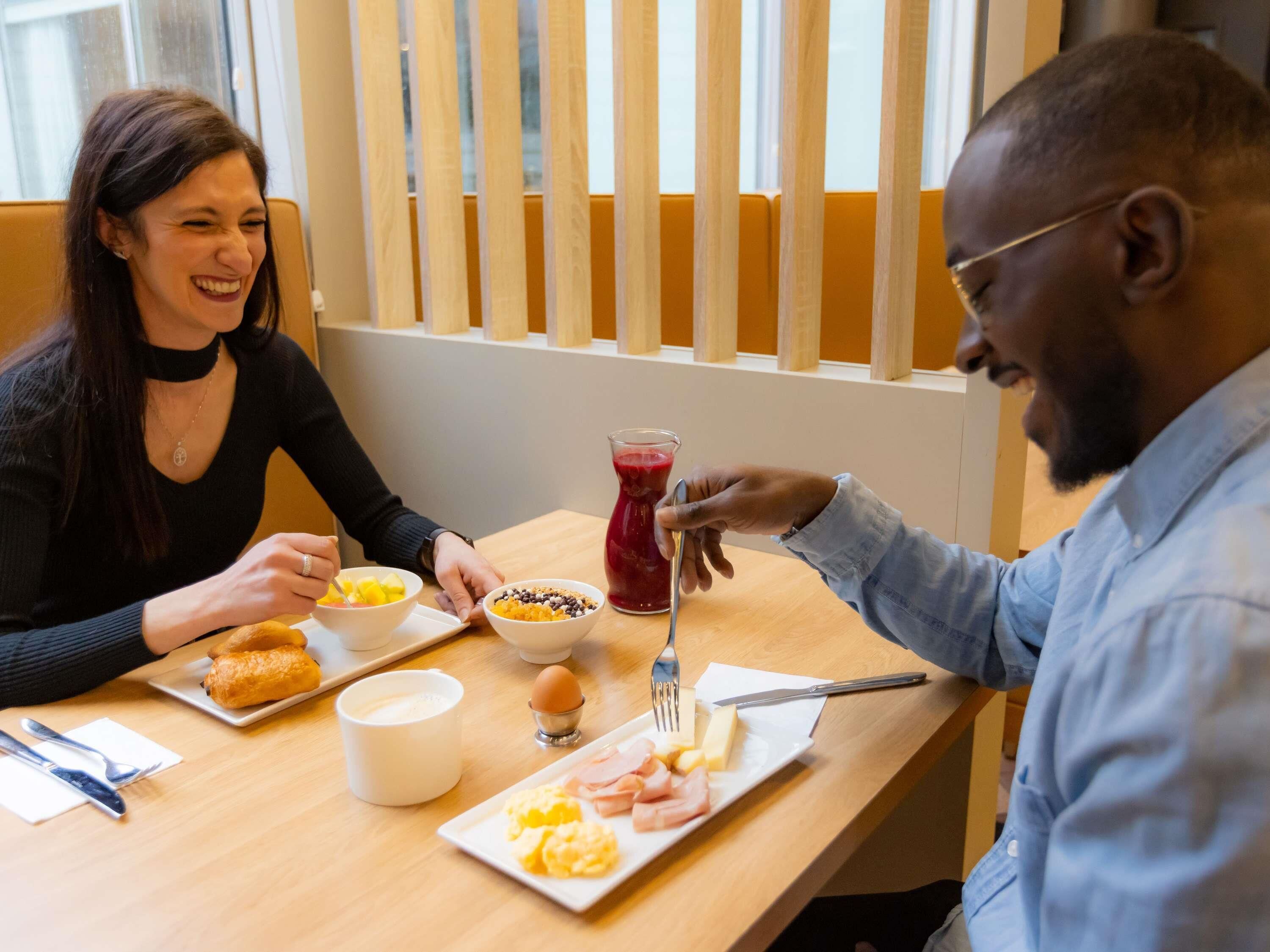 A dining table with food, a pitcher of red drink, and a cup.