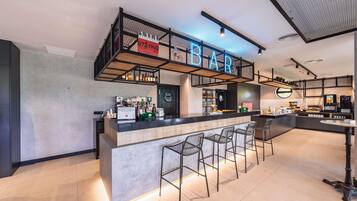 Un'area bar moderna con un bancone, sgabelli e un neon.