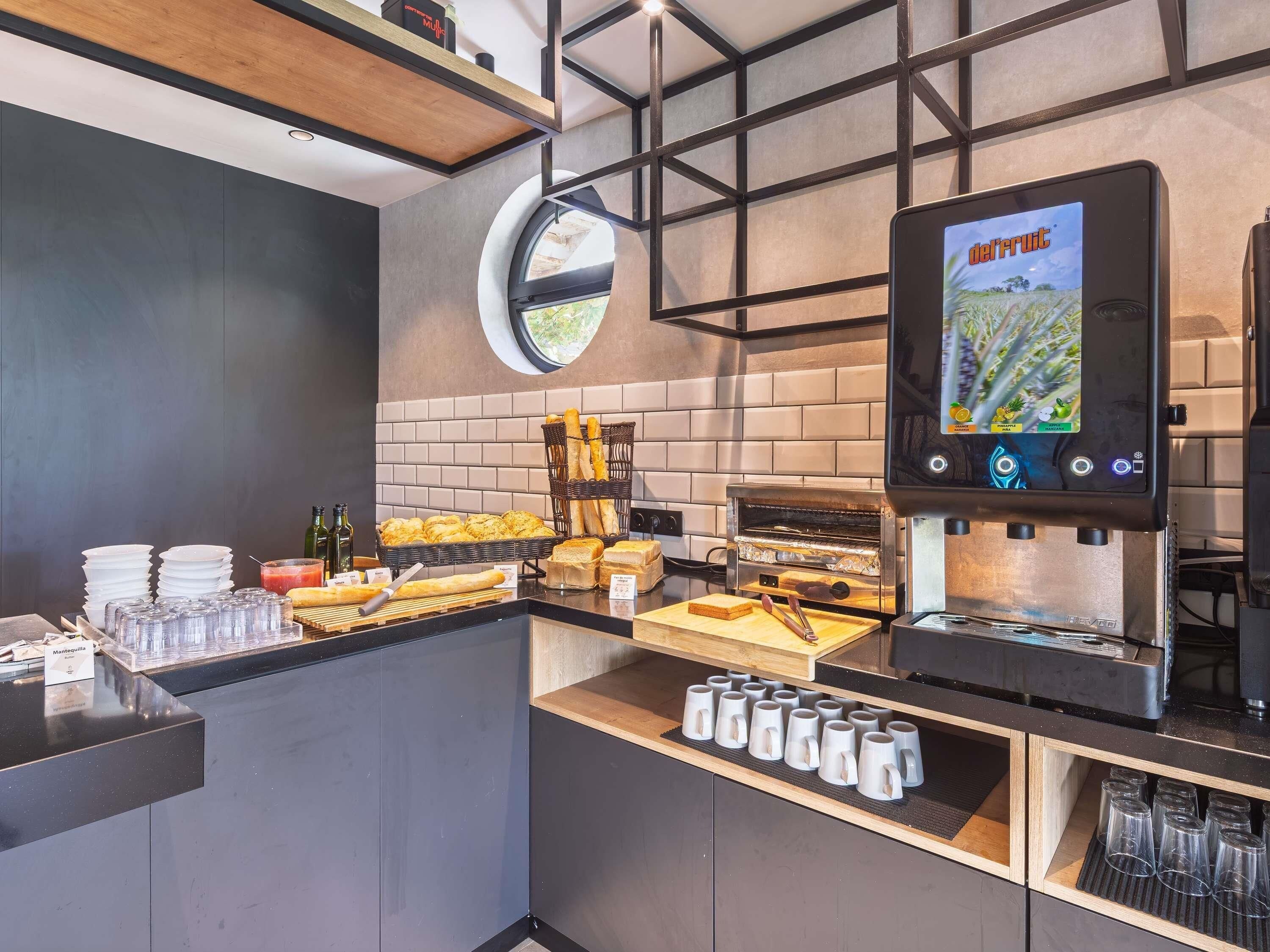 A modern kitchen area with a built-in oven, a digital screen displaying a game, and various food items and utensils.