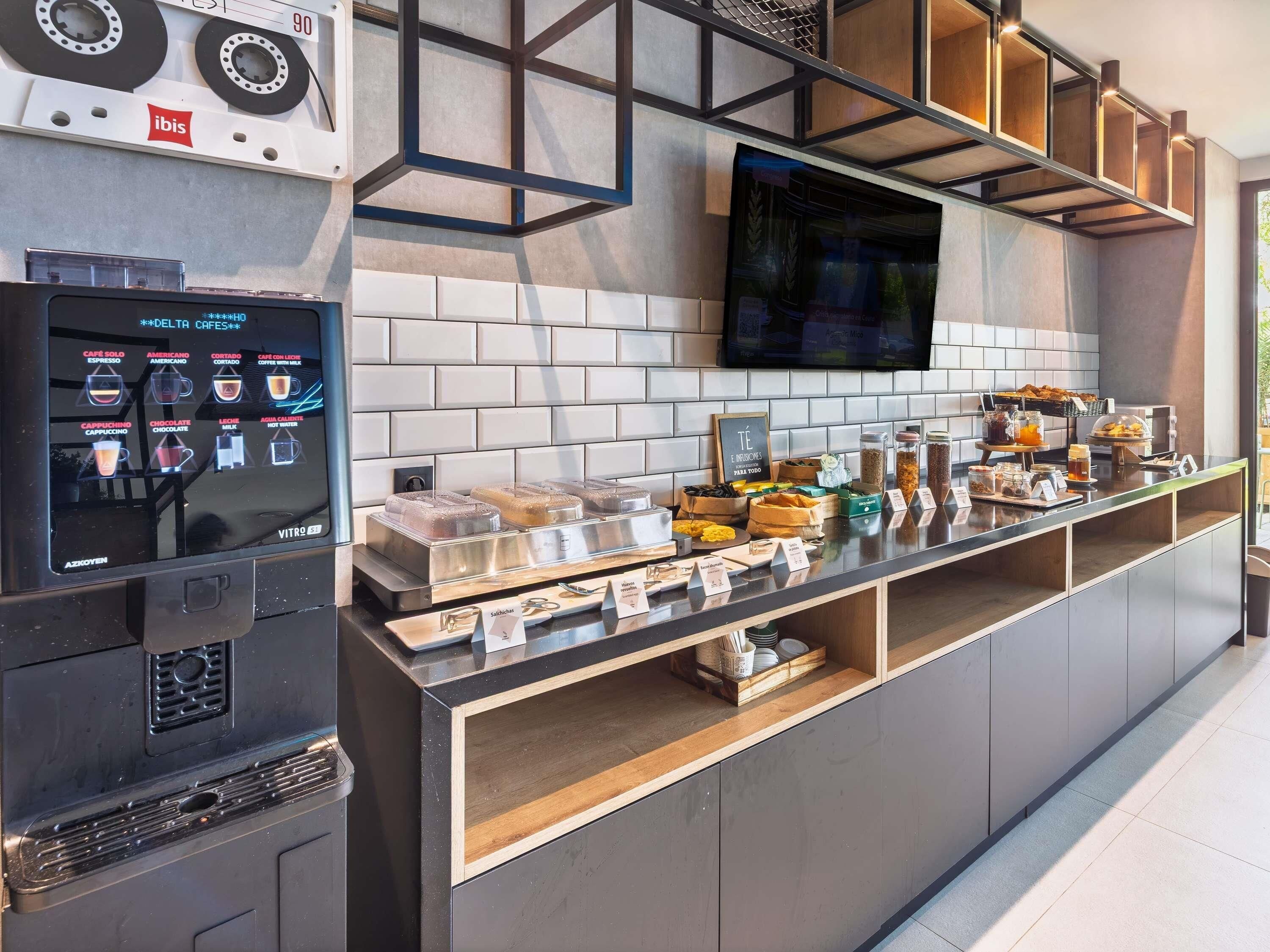 Un espace café en libre-service proposant une variété de boissons et un menu numérique.