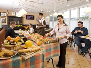 Un buffet proposant une variété de plats et disposant d'un personnel de service.