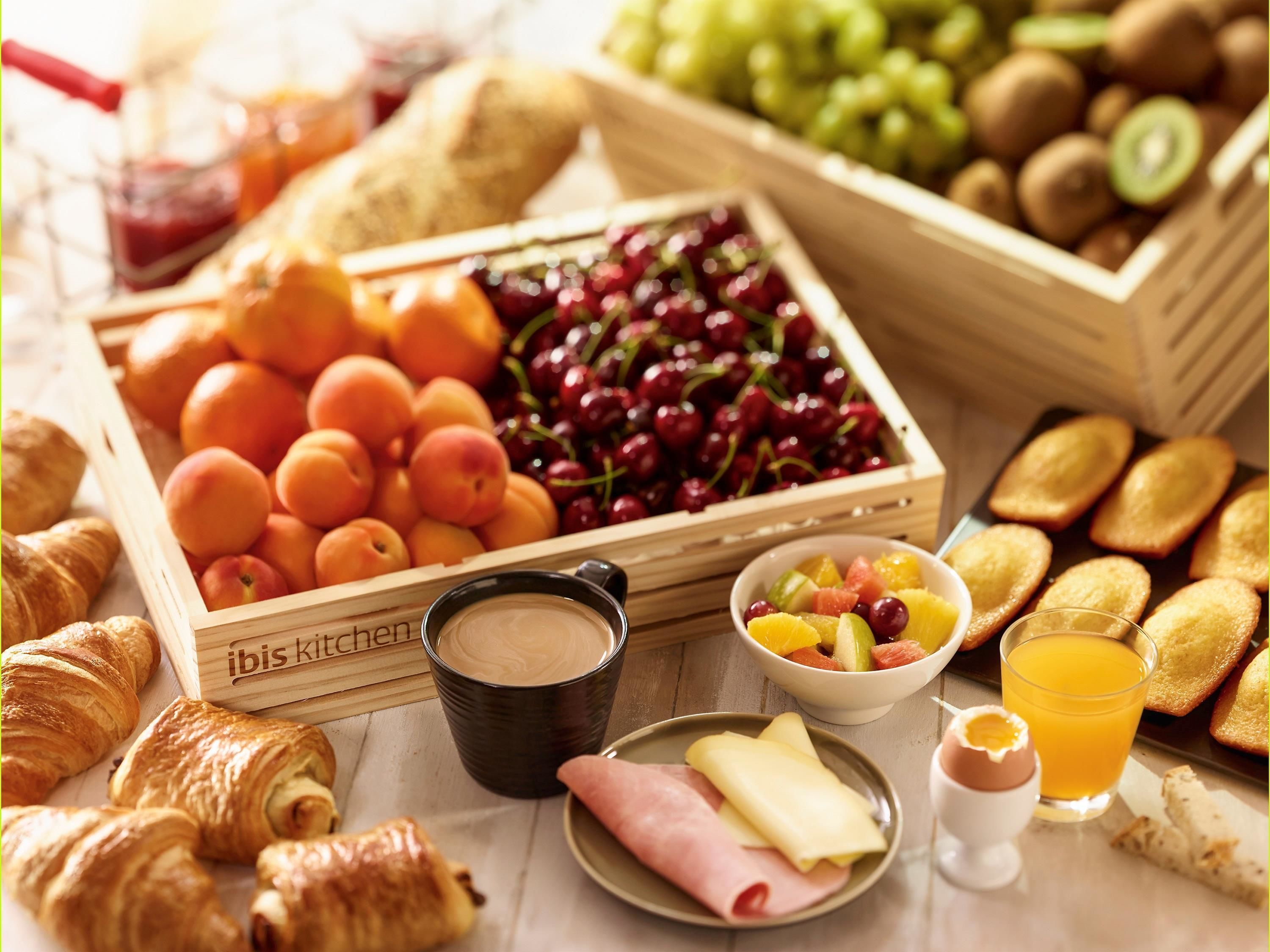A breakfast setting with fruits, pastries, and beverages.
