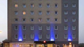 Un edificio de hotel con un letrero que dice 'ibis HOTEL' y varias ventanas.