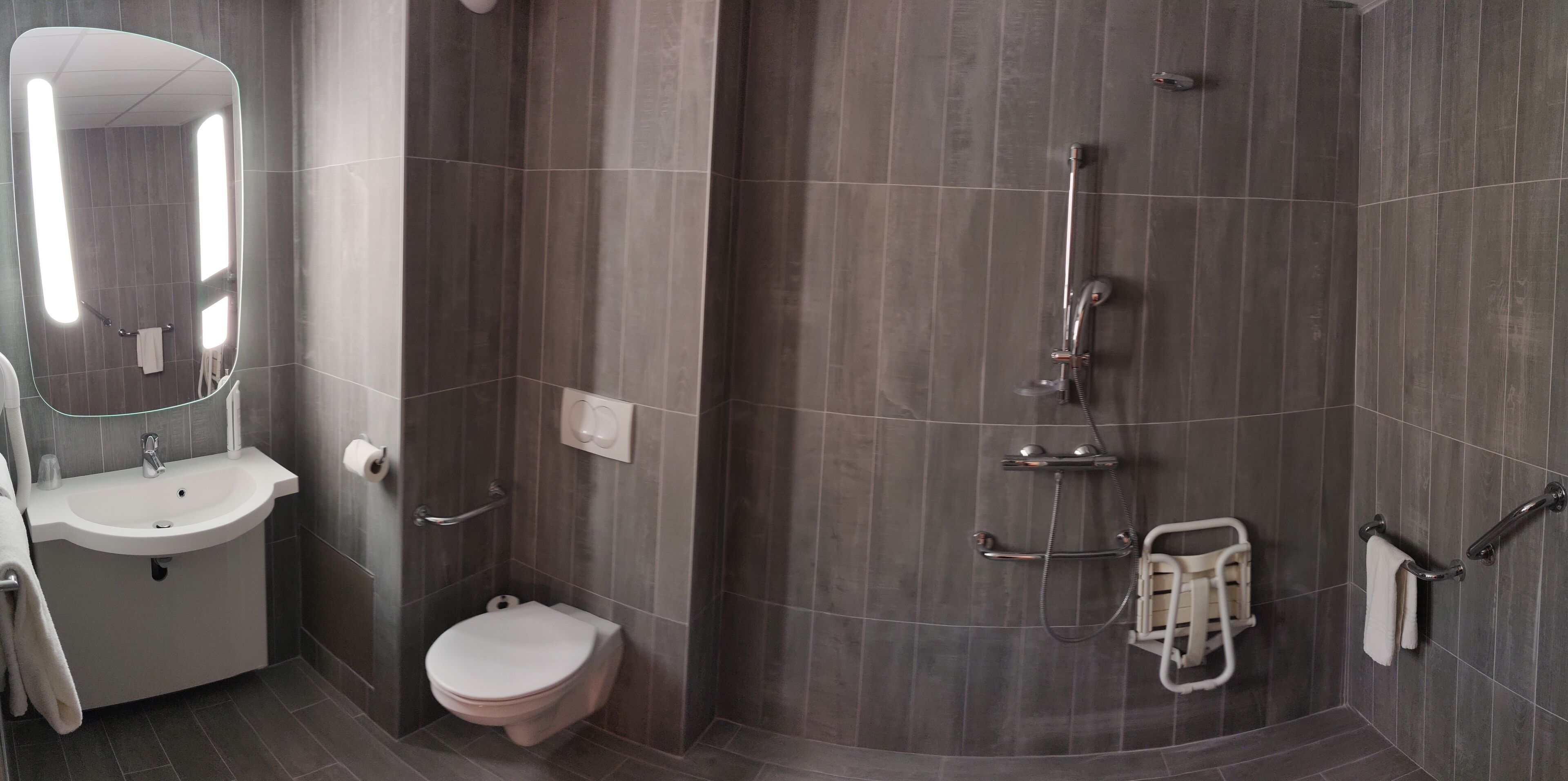 A modern bathroom with a sink, toilet, and shower.