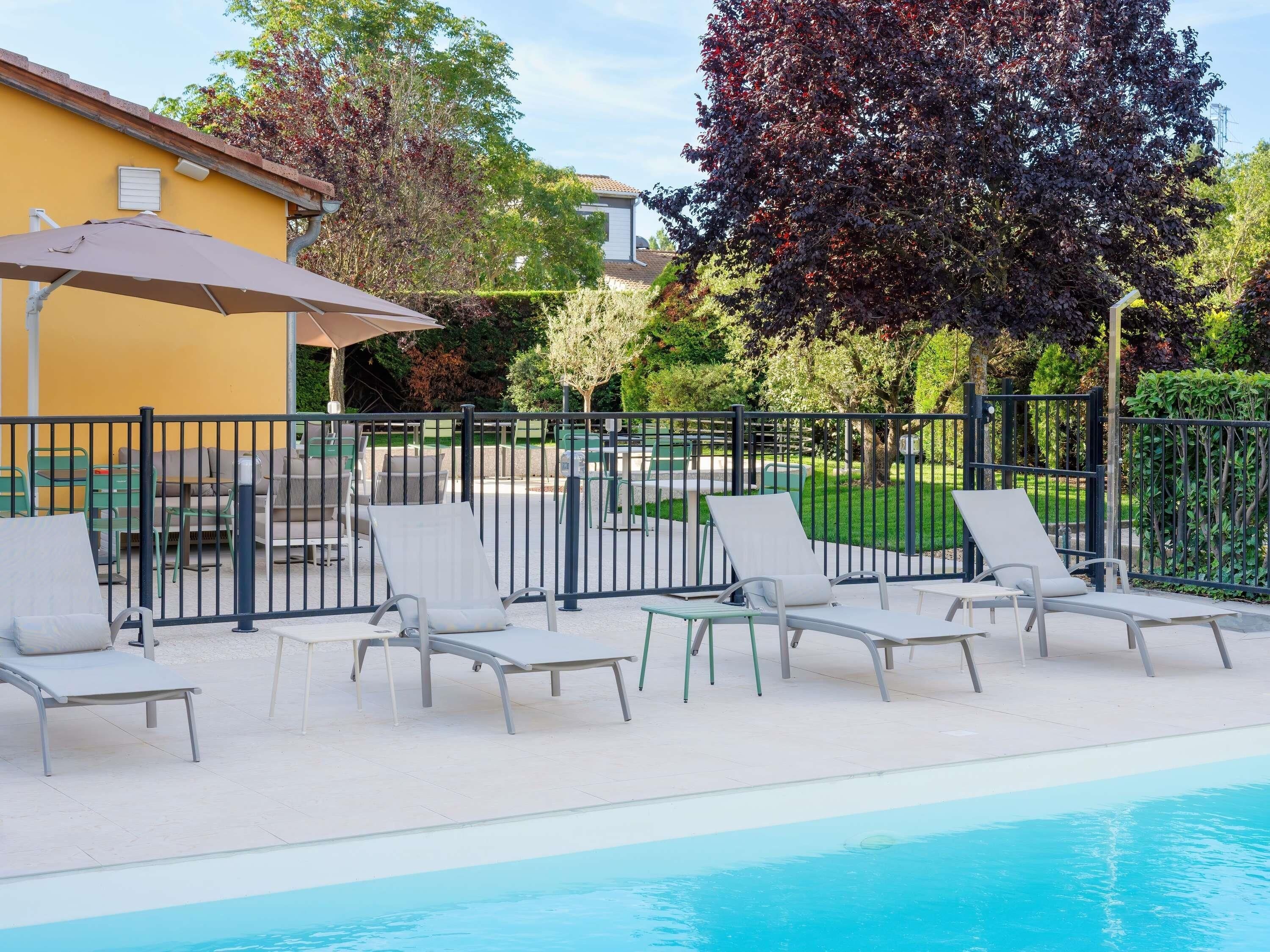 Una piscina al aire libre, tumbonas
