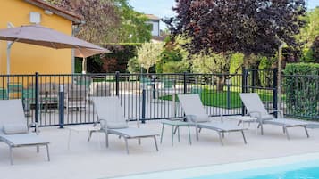 Una piscina al aire libre, tumbonas